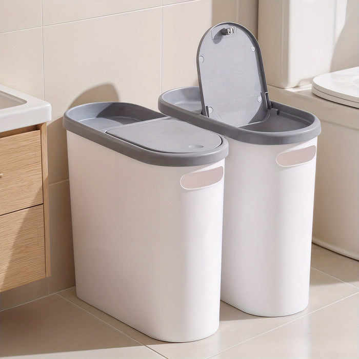 Two white trash bins with gray lids in a bathroom setting.